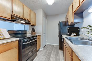 A kitchen with a black stove top oven and a black refrigerator.